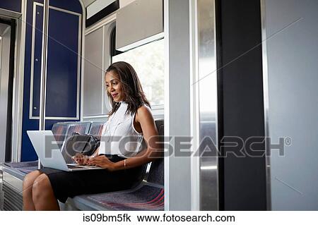 Businesswoman using laptop on train View Large Photo Image Stock Image - Businesswoman using laptop on train. Fotosearch