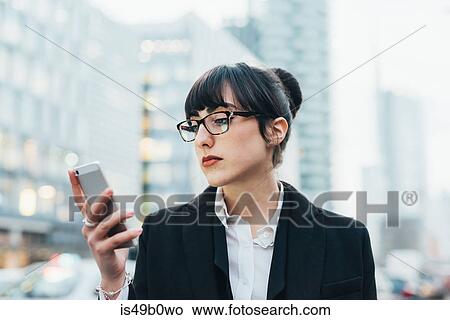 Picture - Businesswoman using mobile, Milan, Italy. Fotosearch