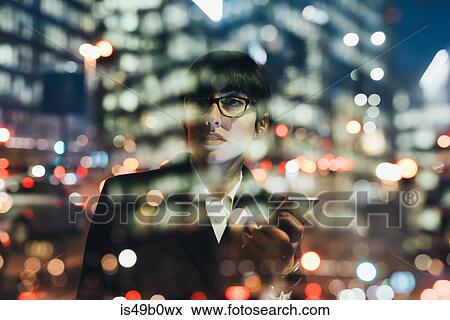 Businesswoman using mobile phone behind glass reflection of buildings, Milan, Italy View Large Photo Image Stock Photo - Businesswoman using mobile phone behind glass reflection of buildings, Milan, Italy. Fotosearch