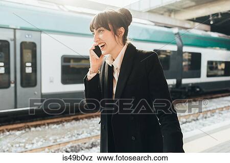 Businesswoman using mobile phone in train station, Milan, Italy View Large Photo Image Stock Photo - Businesswoman using mobile phone in train station, Milan, Italy. Fotosearch
