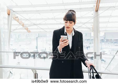 Businesswoman using mobile phone on business trip, Milan, Italy View Large Photo Image Stock Photo - Businesswoman using mobile phone on business trip, Milan, Italy. Fotosearch
