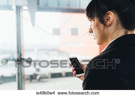 Picture - Businesswoman using mobile phone, Milan, Italy. Fotosearch