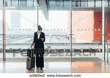 Stock Image - Businesswoman using mobile phone, Milan, Italy. Fotosearch