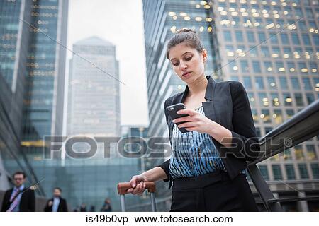 Businesswoman using mobile phone, Canary Wharf, London, UK View Large Photo Image Stock Photography - Businesswoman using mobile phone, Canary Wharf, London, UK. Fotosearch