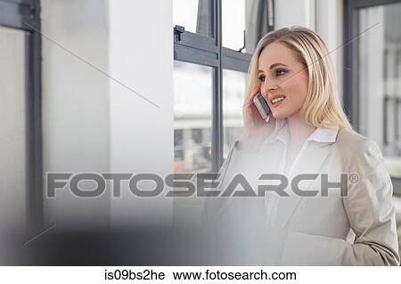 Businesswoman using smartphone in office View Large Photo Image Stock Image - Businesswoman using smartphone in office. Fotosearch