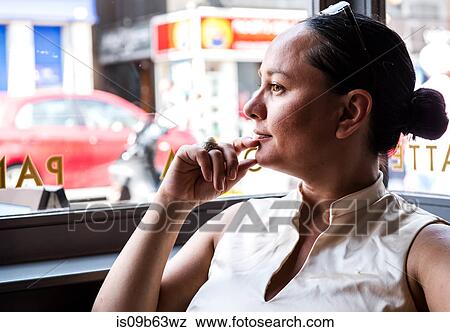Businesswoman with hand on chin in coffee bar View Large Photo Image Stock Photo - Businesswoman with hand on chin in coffee bar. Fotosearch