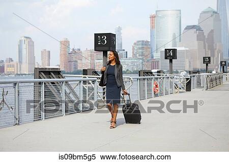 Businesswoman with wheeled luggage on ferry pier View Large Photo Image Stock Photography - Businesswoman with wheeled luggage on ferry pier. Fotosearch