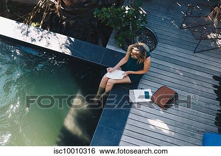 Businesswoman working on edge of swimming pool with legs in water View Large Photo Image Stock Photograph - Businesswoman working on edge of swimming pool with legs in water. Fotosearch