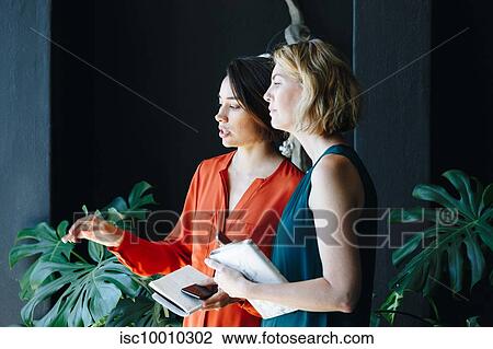 Businesswomen having discussion in office View Large Photo Image Stock Image - Businesswomen having discussion in office. Fotosearch