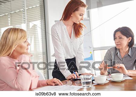 Stock Photo - Businesswomen having discussion in meeting. Fotosearch