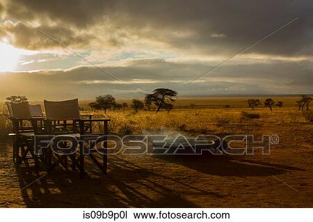 Stock Image - Camp fire and chairs, Tarangire National Park, Tanzania, Africa. Fotosearch