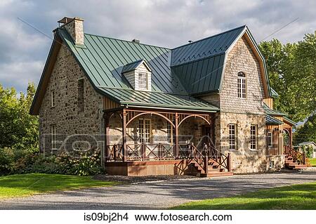 Canadiana cottage style fieldstone house with seam sheet metal roof View Large Photo Image Picture - Canadiana cottage style fieldstone house with seam sheet metal roof. Fotosearch