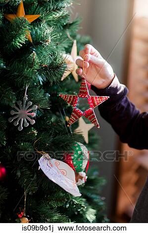 Stock Image - Child putting up Christmas decorations. Fotosearch