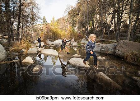 Picture - Children playing on rocks in river, Lake Arrowhead, California, USA. Fotosearch