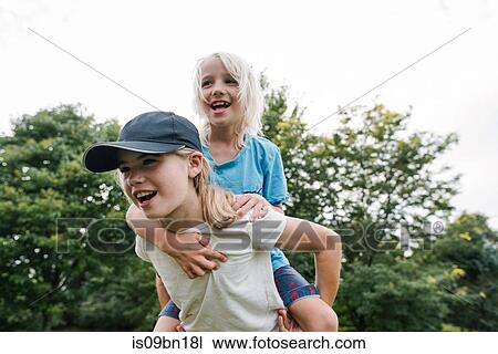 Children playing piggyback in park View Large Photo Image Stock Image - Children playing piggyback in park. Fotosearch