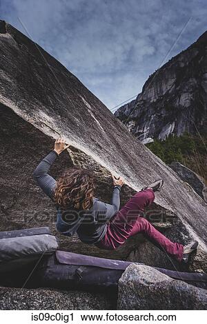 Stock Image - Climber bouldering in forest, Squamish, Canada. Fotosearch