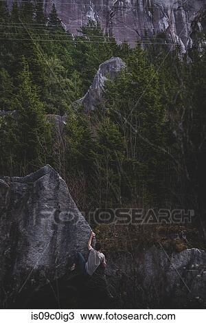 Stock Image - Climber bouldering in forest, Squamish, Canada. Fotosearch
