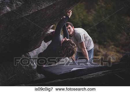 Stock Photo - Climber bouldering, watched by friend, Squamish, Canada. Fotosearch