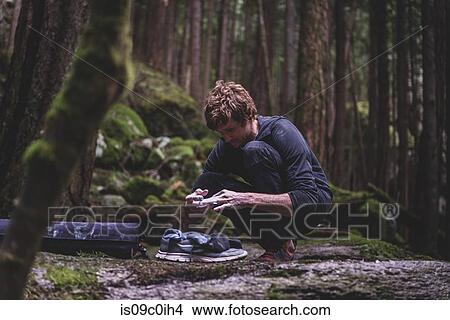 Climber taping fingers before bouldering in forest, Squamish, Canada View Large Photo Image Picture - Climber taping fingers before bouldering in forest, Squamish, Canada. Fotosearch