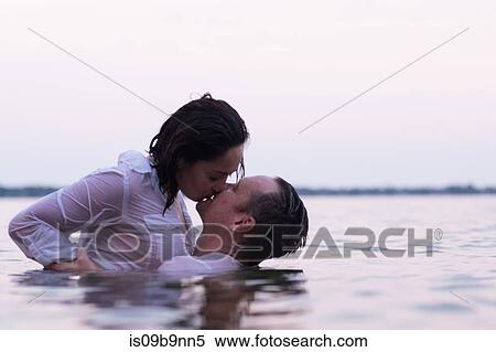 Stock Photography - Clothed couple in water kissing, Destin, Florida, United States, North America. Fotosearch
