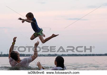 Clothed parents in water throwing son in mid air, Destin, Florida, United States, North America View Large Photo Image Stock Photograph - Clothed parents in water throwing son in mid air, Destin, Florida, United States, North America. Fotosearch