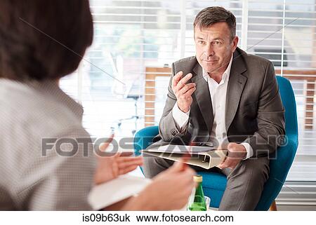 Stock Image - Colleagues having discussion in business meeting. Fotosearch