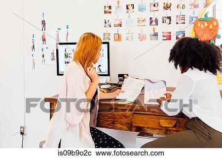 Colleagues in creative studio discussing paperwork View Large Photo Image Stock Image - Colleagues in creative studio discussing paperwork. Fotosearch