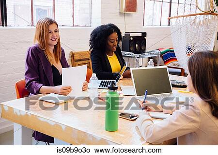 Picture - Colleagues in industrial office building working at desk. Fotosearch