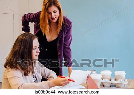 Colleagues in office discussing paperwork View Large Photo Image Picture - Colleagues in office discussing paperwork. Fotosearch