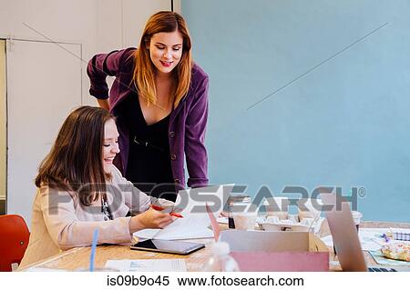 Colleagues in office discussing paperwork View Large Photo Image Stock Photography - Colleagues in office discussing paperwork. Fotosearch