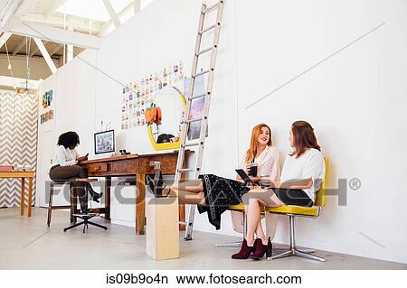 Colleagues in office feet raised taking a break View Large Photo Image Picture - Colleagues in office feet raised taking a break. Fotosearch