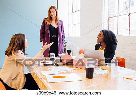 Colleagues in office having discussion View Large Photo Image Stock Photograph - Colleagues in office having discussion. Fotosearch
