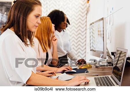 Colleagues in office using laptop together View Large Photo Image Stock Image - Colleagues in office using laptop together. Fotosearch