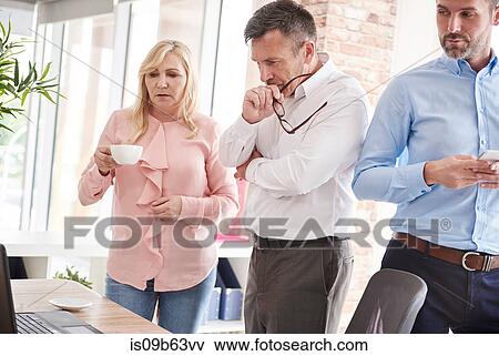 Colleagues in office with laptop having discussion View Large Photo Image Stock Photo - Colleagues in office with laptop having discussion. Fotosearch