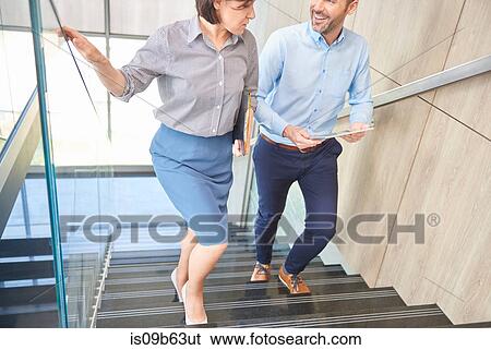 Stock Photograph - Colleagues on stairway chatting. Fotosearch