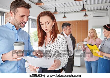 Colleagues standing in office talking View Large Photo Image Stock Image - Colleagues standing in office talking. Fotosearch