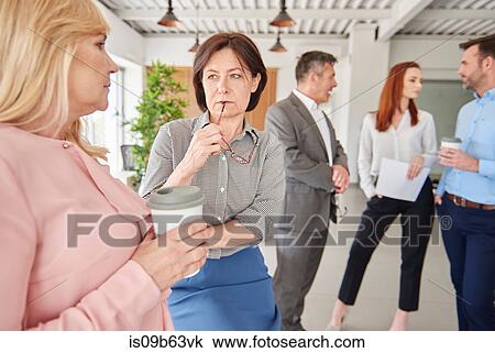 Colleagues standing in office talking View Large Photo Image Stock Image - Colleagues standing in office talking. Fotosearch