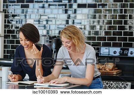 Colleagues talking and working at coffee break in pantry View Large Photo Image Stock Image - Colleagues talking and working at coffee break in pantry. Fotosearch
