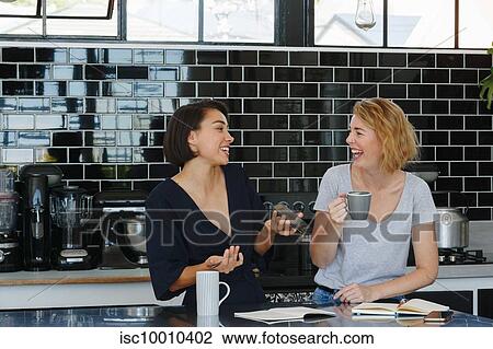 Colleagues talking and working at coffee break in pantry View Large Photo Image Stock Image - Colleagues talking and working at coffee break in pantry. Fotosearch