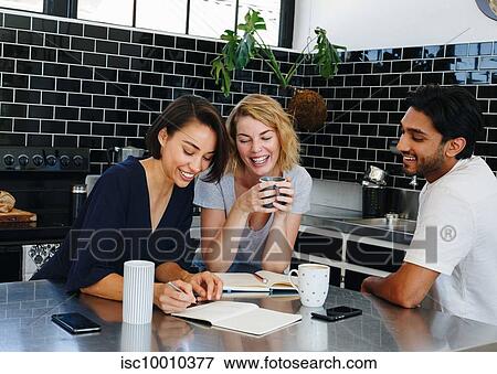 Colleagues talking and working at coffee break in pantry View Large Photo Image Stock Photo - Colleagues talking and working at coffee break in pantry. Fotosearch