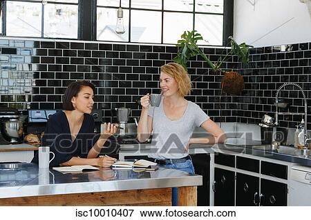 Colleagues talking and working at coffee break in pantry View Large Photo Image Stock Photo - Colleagues talking and working at coffee break in pantry. Fotosearch