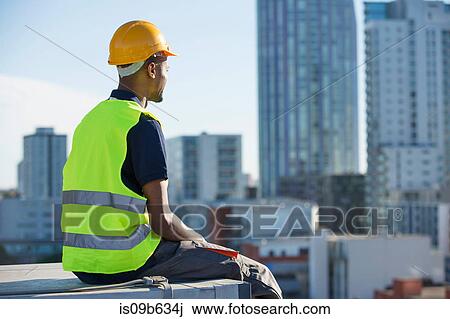 Construction worker sitting on ledge, outdoors, taking a break View Large Photo Image Stock Image - Construction worker sitting on ledge, outdoors, taking a break. Fotosearch