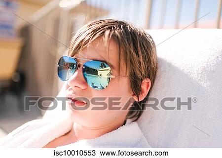 Cool teenage boy wearing mirror image sunglasses on sun lounger at hotel poolside, head and shoulders, Las Vegas, Nevada, USA View Large Photo Image Stock Image - Cool teenage boy wearing mirror image sunglasses on sun lounger at hotel poolside, head and shoulders, Las Vegas, Nevada, USA. Fotosearch