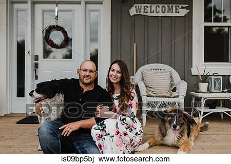 Couple and their two dogs sitting on porch View Large Photo Image Stock Image - Couple and their two dogs sitting on porch. Fotosearch