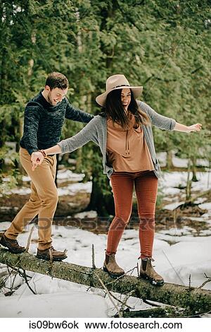 Couple balancing on fallen tree trunk in forest, Tobermory, Canada View Large Photo Image Stock Image - Couple balancing on fallen tree trunk in forest, Tobermory, Canada. Fotosearch