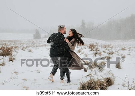 Stock Image - Couple dancing in snowy landscape, Georgetown, Canada. Fotosearch
