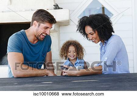Couple e-learning with daughter on smartphone in beach house View Large Photo Image Stock Photo - Couple e-learning with daughter on smartphone in beach house. Fotosearch