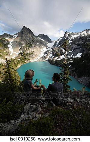 Couple enjoying scenic view, Alpine Blue Lake, Washington, USA View Large Photo Image Stock Photo - Couple enjoying scenic view, Alpine Blue Lake, Washington, USA. Fotosearch