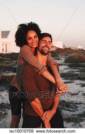 Couple enjoying view of sunset on beach View Large Photo Image Stock Photo - Couple enjoying view of sunset on beach. Fotosearch