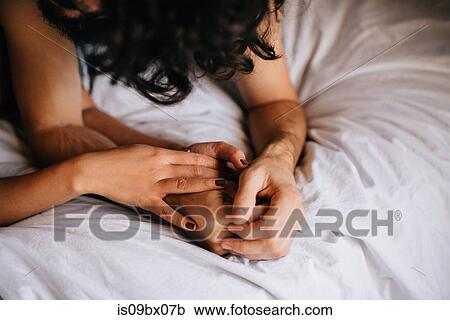 Couple holding hands in bed View Large Photo Image Stock Image - Couple holding hands in bed. Fotosearch